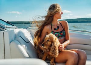 girl with long hair on the boat with a dog smiling